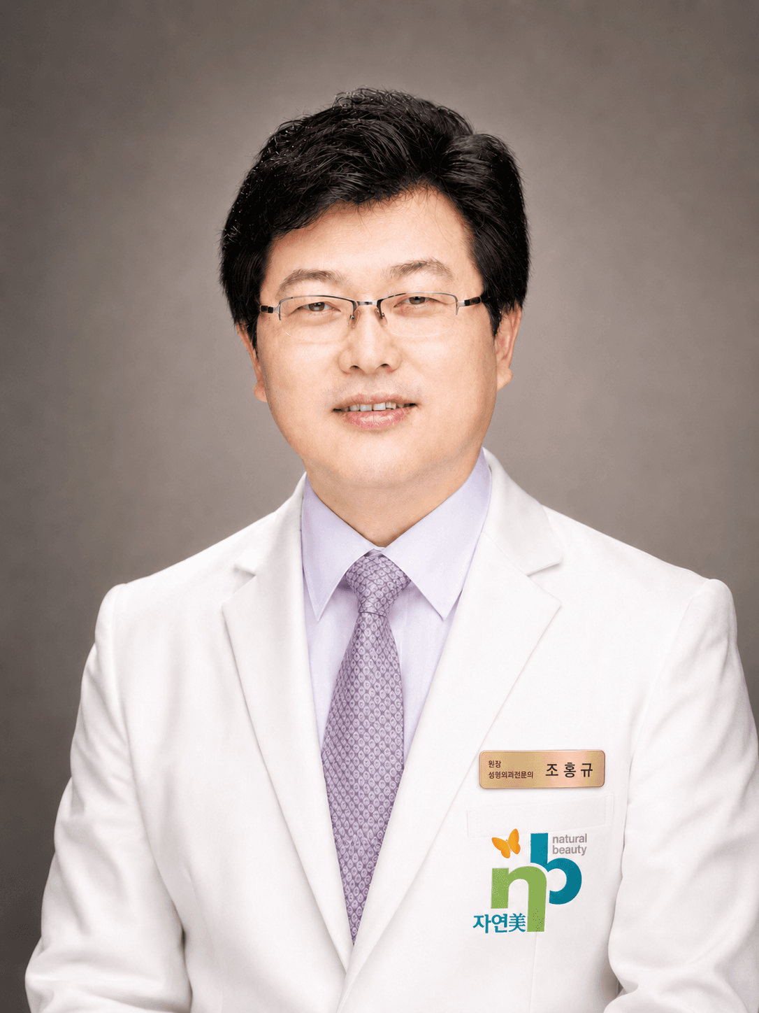 CHO HONG KYU, Chief Director of NB Plastic Surgery — plastic surgery specialist with 25 years of clinical experience (in NB gown and name tag)
